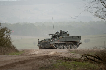 Wall Mural - British army Warrior FV510 with commander in action, moving across countryside