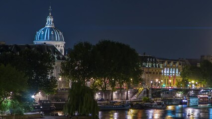 Wall Mural - River Seine with Pont des Arts and dome of Institut de France at night timelapse from Pont Neuf in Paris, France. Illumination reflected on water