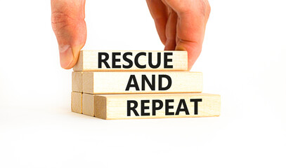 Rescue and repeat symbol. Concept words Rescue and repeat on wooden block on a beautiful white table white background. Businessman hand. Business rescue and repeat concept. Copy space.