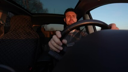 Canvas Print - Man driving car at sunset light interior view