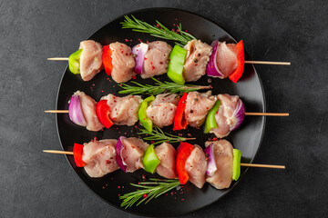 Skewers with raw chicken meat pieces with vegetables, pepper and onion for cooking chicken kebab or bbq. Top view