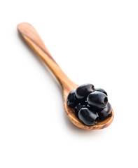 Wall Mural - Pitted black olives in spoon isolated on white background.