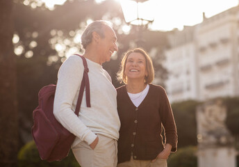 Wall Mural - Positive Senior Spouses Laughing Standing With Backpack Enjoying Vacation Outdoors