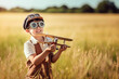 © Victor - Little kid flying a homemade plane in a field at summer.