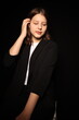 © Anhelina  - portrait of a beautiful young brunette woman in a black blouse on a black background. strict portrait of a girl on a black background
