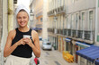 © Andriy Medvediuk - Young beautiful woman in a towel on head is drinking coffee or tea and smiling cute standing on balcony on ueropean street background. lifestyle morning. Concept of domestic or traveling lifestyle.