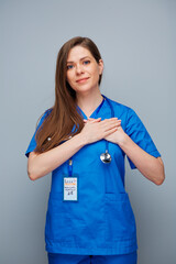 Wall Mural - Smiling doctor woman or nurse holding folded hands on chest.