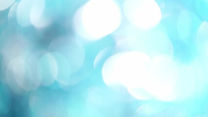 Wall Mural - Blue And White Bokeh Motion Background. Abstract movement of light blue defocused circles and light reflexes. Glowing silky soft bokeh soft motion.