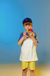 © dashamuller - Cheerful emotional boy in a cap with popit at blue and yellow color studio background