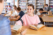 © JackF - Ten-year-old schoolgirl who came to the school library passes books to the librarian
