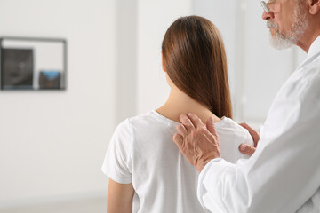 Canvas Print - Professional orthopedist examining patient's neck in clinic, closeup