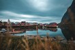 Gloomy sky over the calm lake with red buildings in Norwegen, Lofoten, Fischerdorf Reine