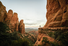 Wide Angle View Of Woman Standing At Sunset From Cathedral Rock In Sedona.