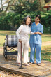 © NanSan - Young asian care helper with asia elderly woman on wheelchair relax together park outdoors to help and encourage and rest your mind. using crutches and cane help support yourself to walk