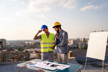 Wall Mural - Group of diversity architect people meeting and planning a project together at construction site.