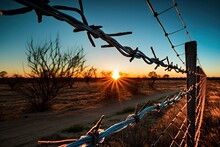 Barbed Wire Fence With A View Of The Sunset, Against A Backdrop Of Clear Blue Sky, Created With Generative Ai