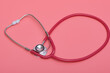Czerwony stetoskop medyczny na różowym tle