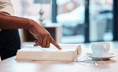 Hand, bible and a person reading in a cafe for religion, belief or faith in god and jesus. Education, learning and pointing with an adult in a coffee shop to study for spiritual knowledge in christ