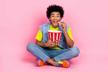 Canvas Print - Full length photo of cheerful funky crazy positive man sitting eating popcorn interesting plot cartoon isolated on pink color background