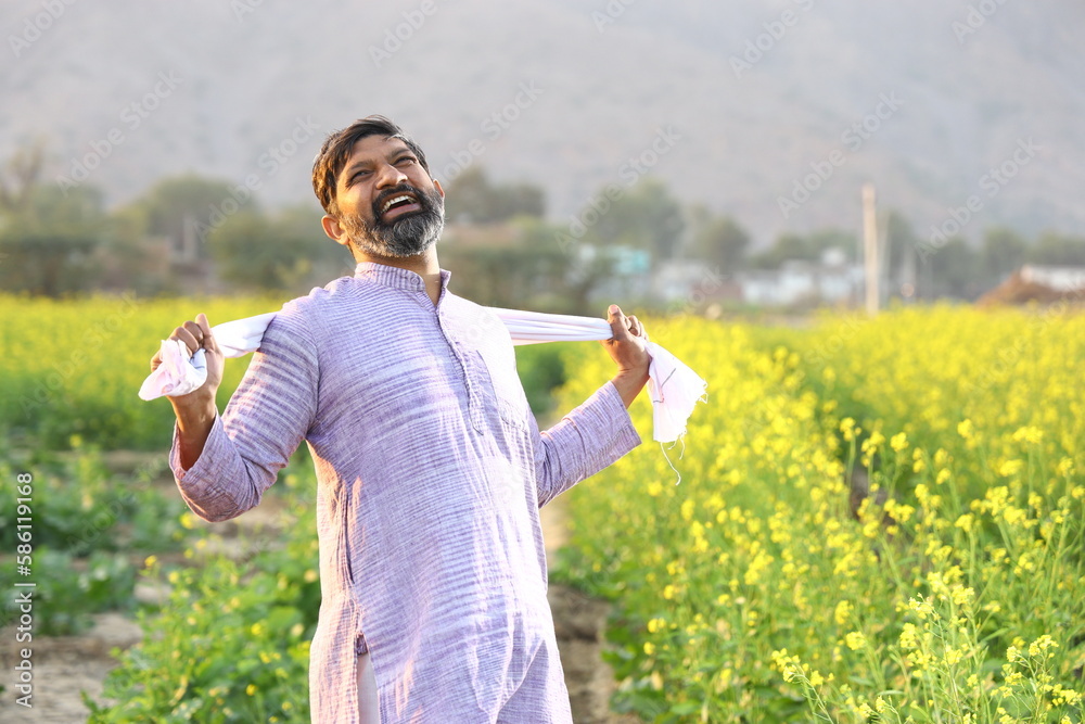 Happy rural Indian farmer enjoying the wind while stretching his scarf ...