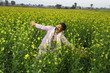© Maahir - Happy Indian farmer enjoying the wind standing in the field spreading his arms and looking up in the sky.