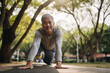 © ink drop - A happy older man doing stretching exercise outdoors. Generative ai