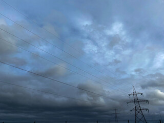 Grey blue sky and an electrical transmission power pylon. 