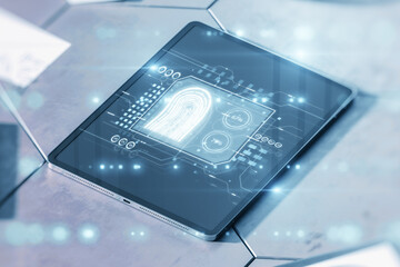 Poster - Close up of tablet on desktop with creative fingerprint hologram on blurry background. concept of fingerprint, biometrics, information technology and cyber security. Mixed media. Double exposure.
