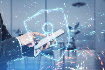 Poster - Close up of male hand using cellphone with glowing safety shield icon on blurry office interior background. Secure, protection and web surfing concept. Double exposure.