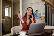 © Studio Dva Kera - Pretty young woman having a phone conversation at home, while her husband is in the kitchen.
