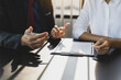 © Wasan - Businessman in suit in his office showing an insurance policy and pointing with a pen where the policyholder must to sign. Insurance agent presentation and consulting insurance detail to customer.