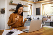 © N Lawrenson/peopleimages.com - Laptop, success and business woman celebrating finance, savings and investment growth in a kitchen. Online, victory and freelance female excited for good news, loan and startup approval in her home