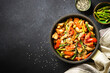 Chicken stir fry with vegetables at stone background. Top view with copy space.