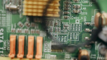 Poster - Close-up. An electronic engineer examines the details of an electronic board through a magnifying glass.