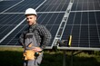 © Serhii - Male worker in uniform outdoors with solar batteries at sunny day.