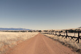 Fototapeta  - A lonely dirt road through the grasslands along the border between the United States and Mexico in Arizona.