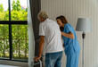 © jiradet_ponari - A nurse helps an elderly patient walk with a walker in a nursing home.