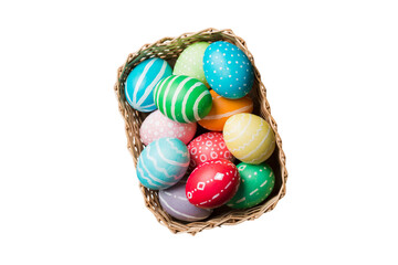 Basket of colorful Easter eggs isolated on white background. Easter basket filled with colored eggs top view holiday concept