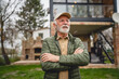 © Miljan Živković - One senior man stand outdoor in front of his house happy confident