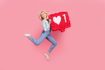 Sticker - Full length photo of shiny sweet lady dressed flower print cardigan holding heart pinata jumping high isolated pink color background