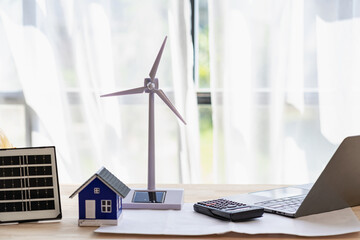 wind turbines and solar cells. house on the table. renewable energy concept.