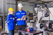 © Quality Stock Arts - Engineer team man and woman working together training help support work with robot welding machine service.