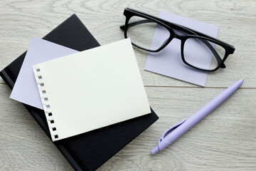 Wall Mural - Blank sheet of white paper on a wooden table. view from above. purple pen and purple sticker