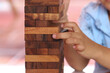 Wooden puzzle game align vertically and finger of child in toy concept.