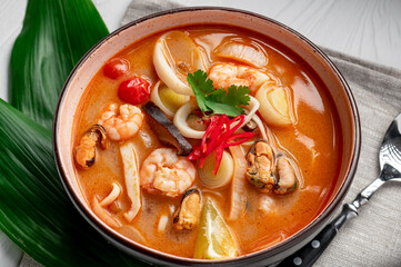 Canvas Print - Spicy Asian tom yum soup with shrimp, squid, mussels and vegetables. Asian cuisine.