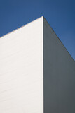 Fototapeta  - white wall, contrast between light and shadow, blue sky behind
