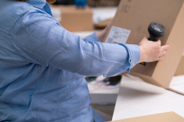 Poster - logistic shipping online orders concept. close up scanning barcode on package delivery, e-commerce