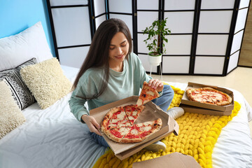 Wall Mural - Young woman with boxes of tasty pizza sitting in bedroom