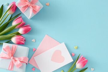 Wall Mural - Flat lay composition of present boxes with bows postcard hearts baubles pink tulips flowers on isolated pastel blue background with empty space. Happy Mother's Day concept