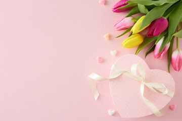Wall Mural - Top view photo of heart shaped gift box with bow colorful tulips flowers hearts baubles on isolated pastel pink background with copyspace. Happy Mother's Day concept